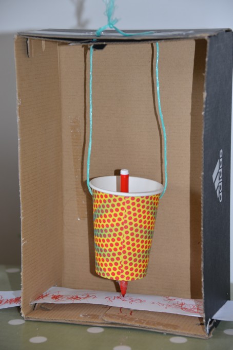 Homemade seismometer using a cardboard box, cup, pencil, string and paper. #earthquakescienceforkids #earthquakescience
