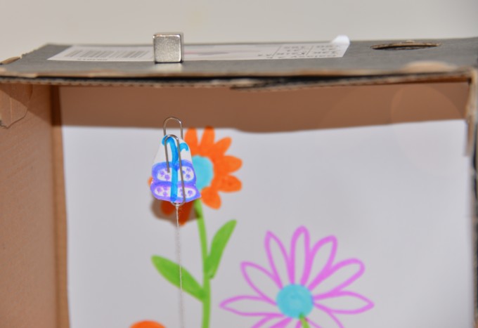 Shoebox decorated with flowers with a strong magnet attracting a paperclip to the top