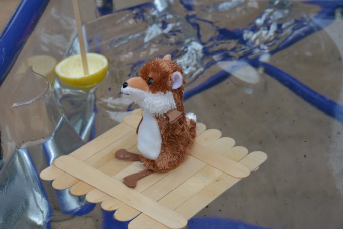 A raft made of wooden lollipop sticks with a toy wolf on it for a summer STEM challenge