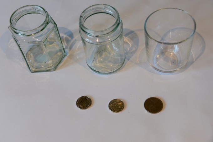 three glass jars and three coins for a disappearing coin trick