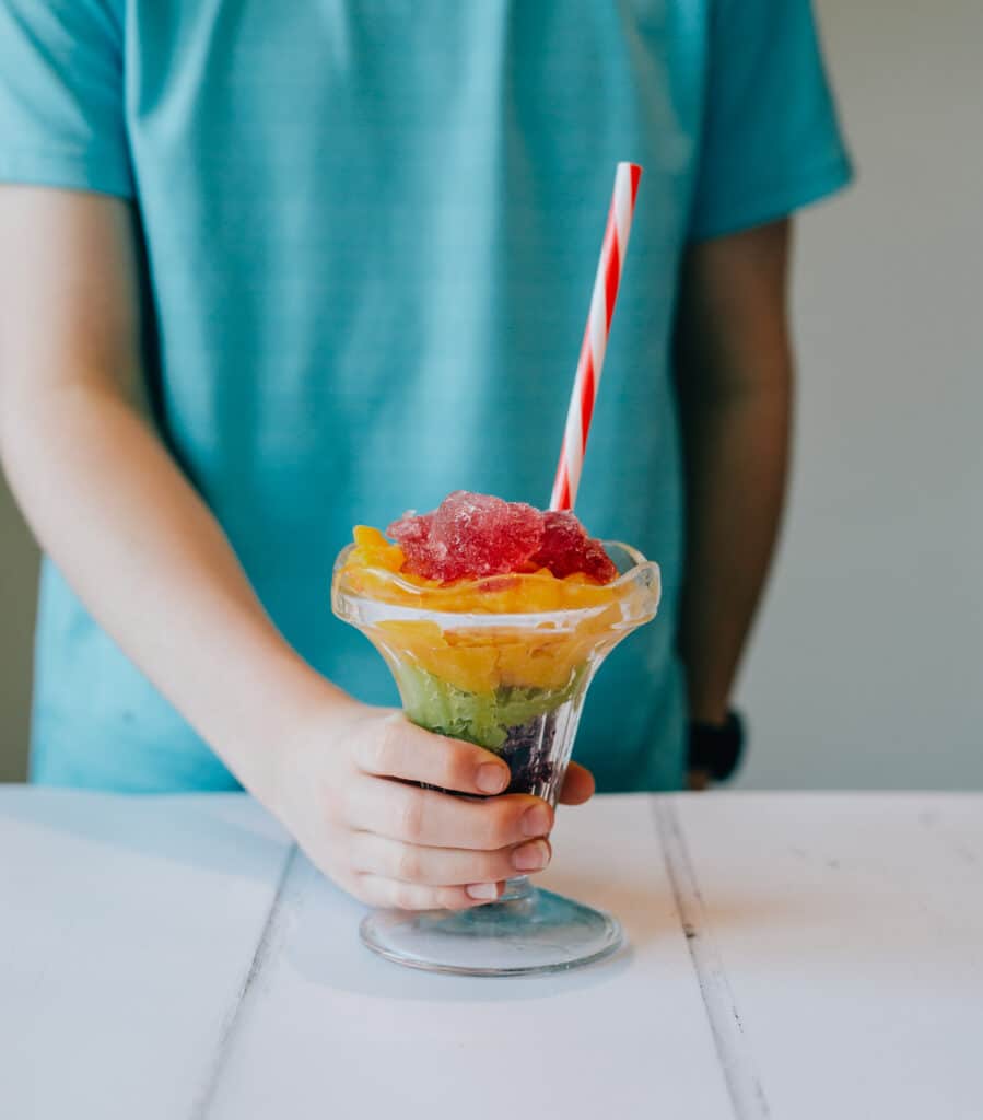 child holding a slush drink made with ice and salt