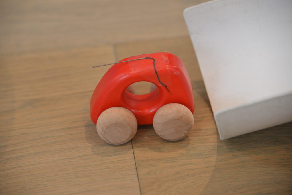 A wooden toy car with a needle sellotaped to the top to pop a balloon as a final stage in a chain reaction 