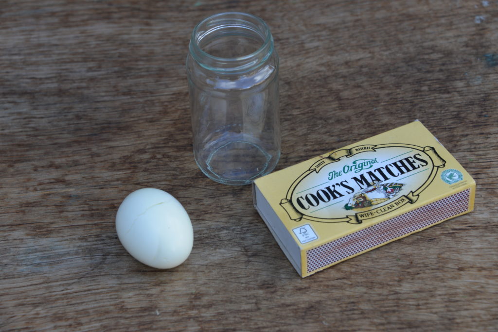 image of a boiled egg and a jar ready for an egg in a bottle experiment