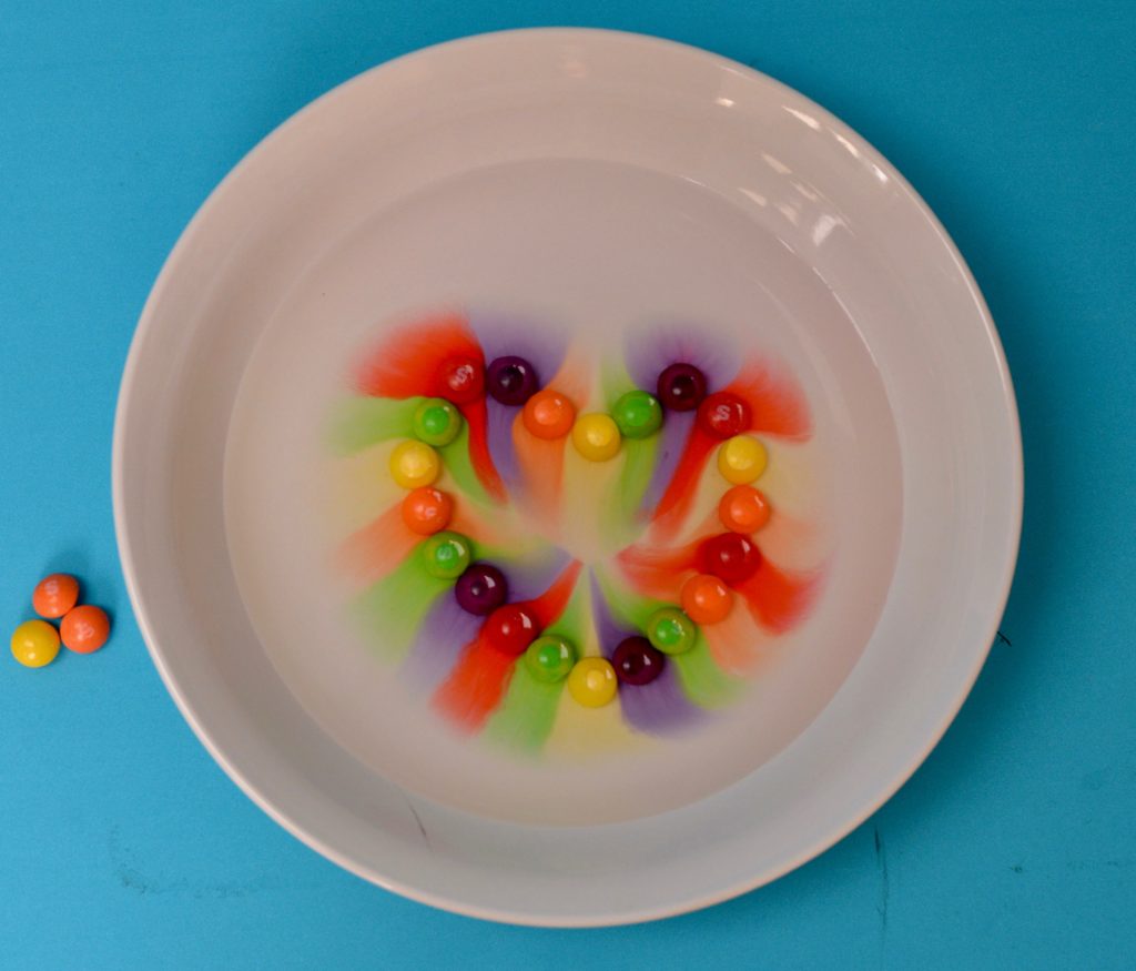 Bolos en un plato en forma de corazón.  Se vertió agua sobre los bolos y el color del caramelo se esparció por el agua.