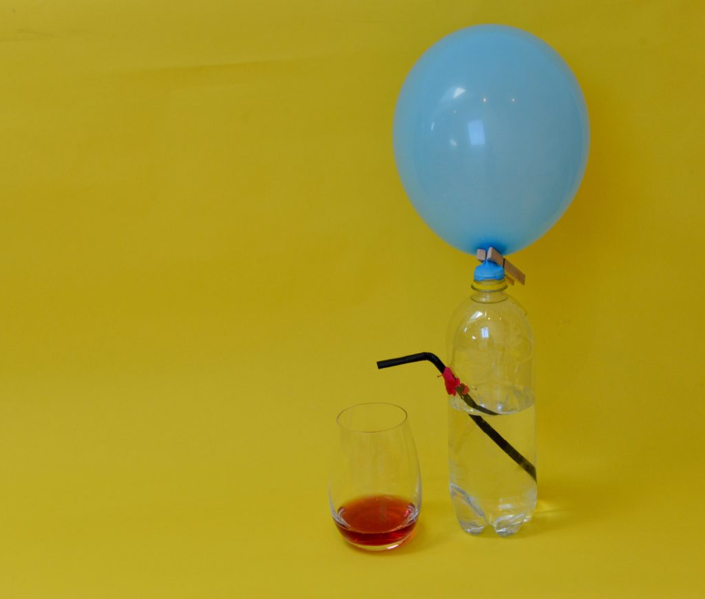 drinks dispenser made with a balloon and plastic bottle for a science investigation about air pressure.