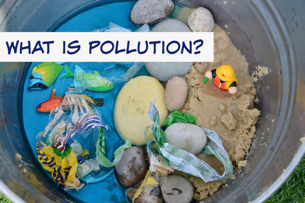 Image of a metal tray with sand, blue water, plastic fish and rubbish to show the effects of pollution on marine life.