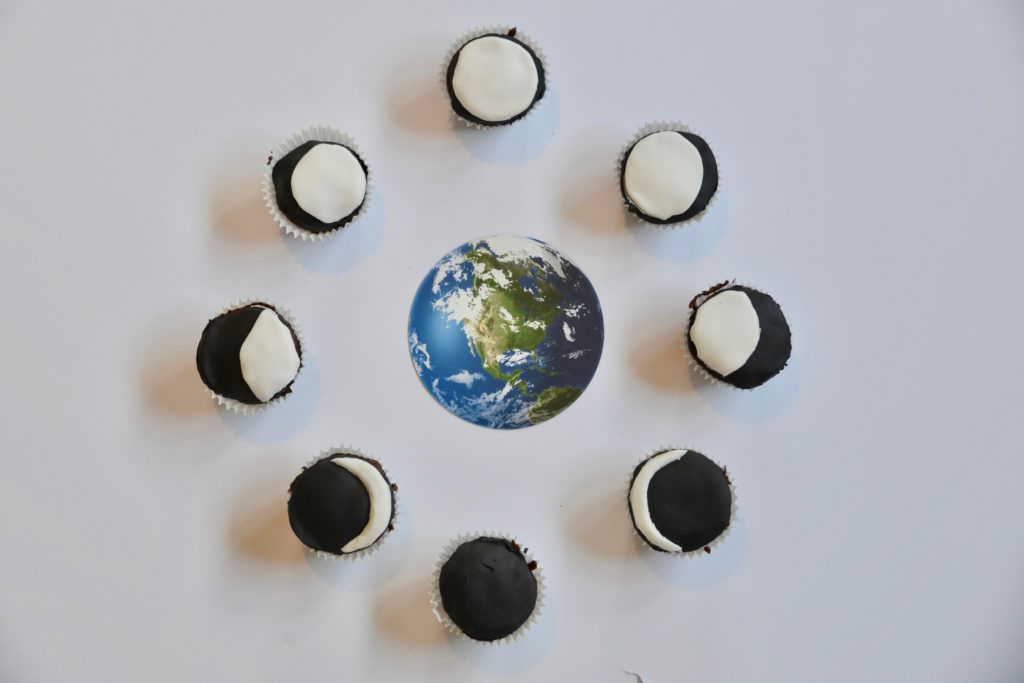 moon phase cupcakes made with chocolate cake and icing to show the moon