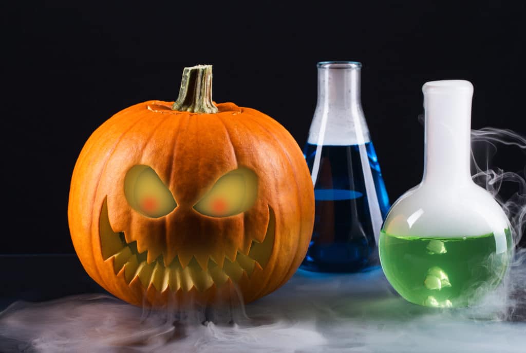 scary pumpkin image with test tubes emitting fog.