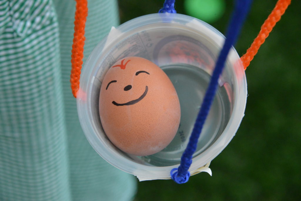 An egg in a container connected to a parachute for a Jack and the Beanstalk science experiment