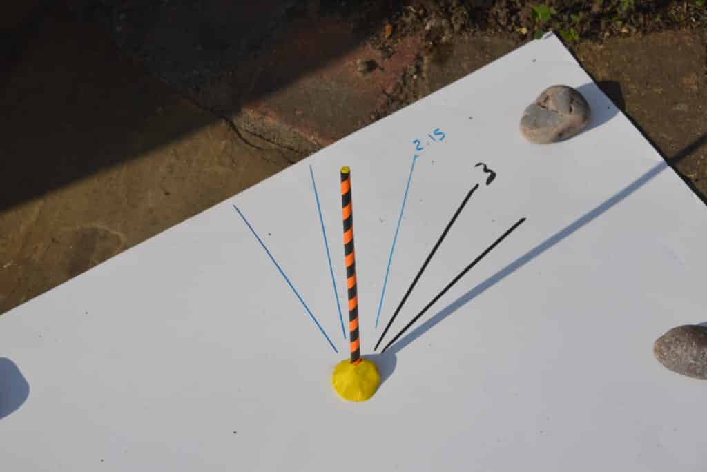 Simple sundial made by placing a straw in plasticine outside and marking how the shadows change throughout the day.