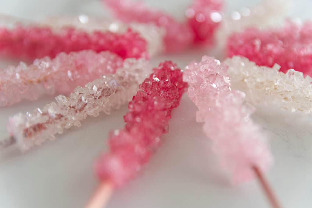 pink and white rock candy lollypops made from a saturated sugar solution as part of a science experiment