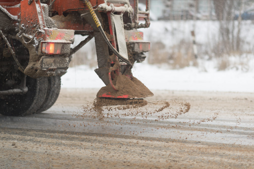 Image of a grit truck dropping grit on a road