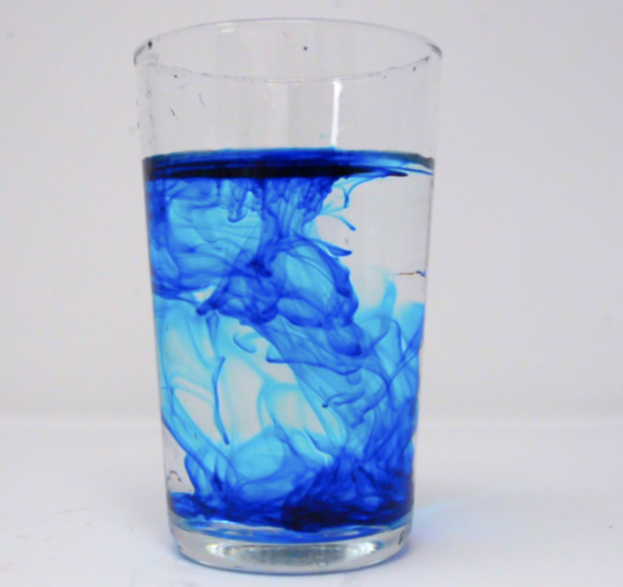 Blue food colouring spreading through water for a diffusion demonstration