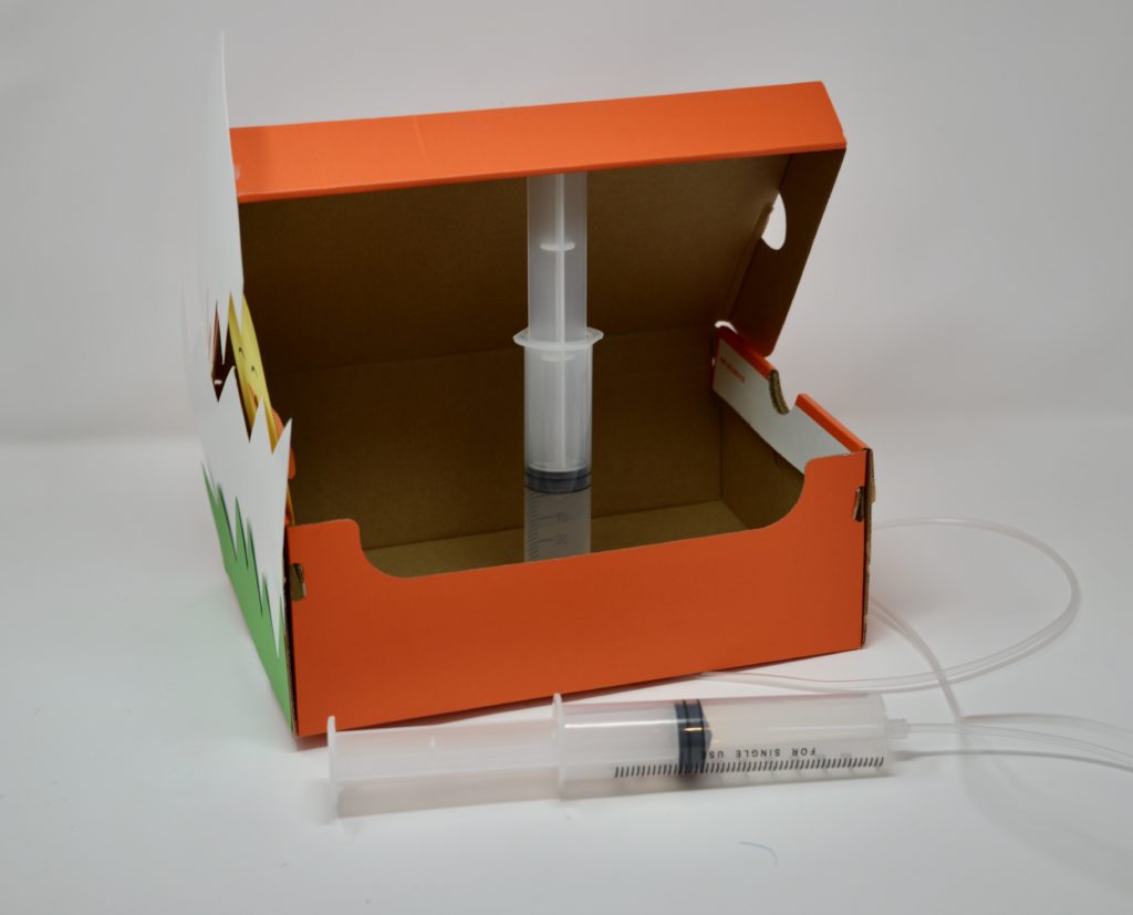 Shoebox with a syringe inside used for a pneumatics project