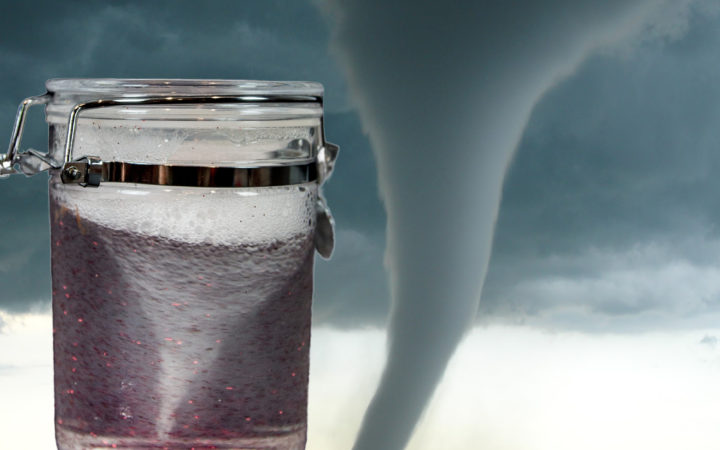 Image of a tornado in a jar with a background of a real tornado
