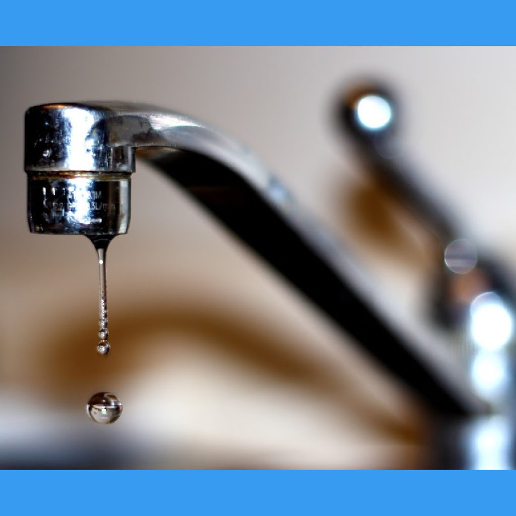 Water dripping from a tap, showing  a spherical water droplet