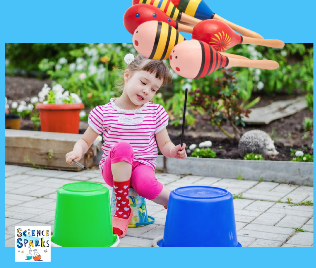 Image shows a young girl banging bucket drums