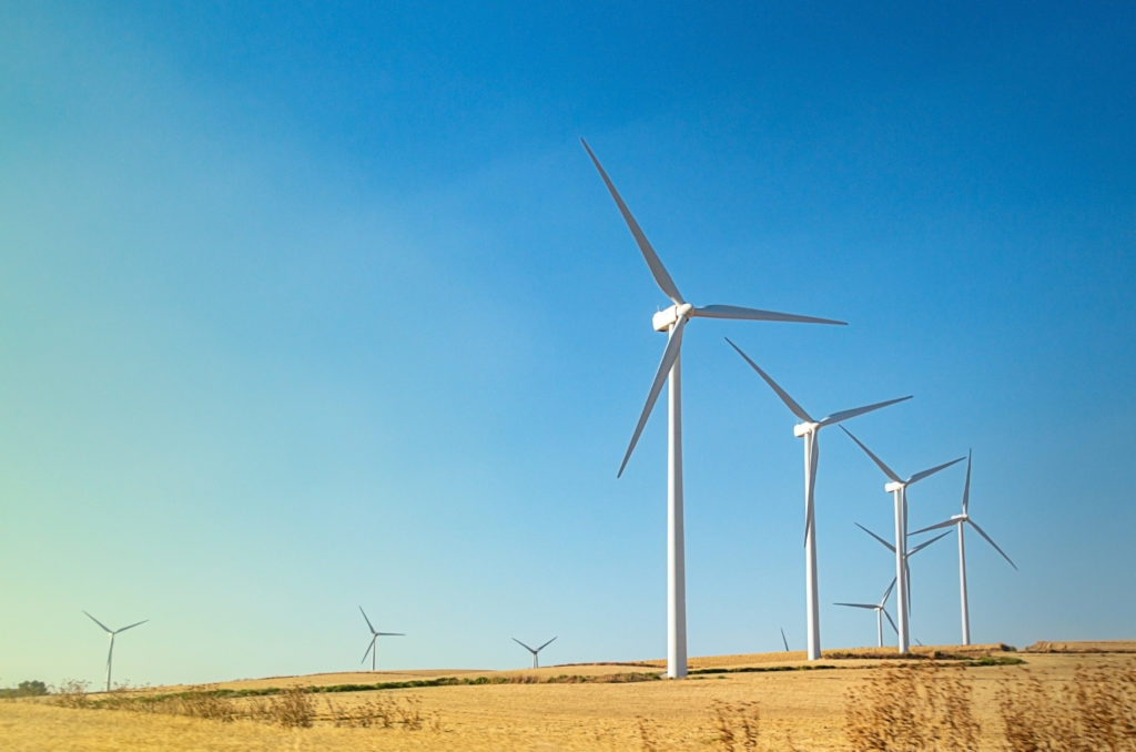 Image of a wind farm showing wind turbines in a row