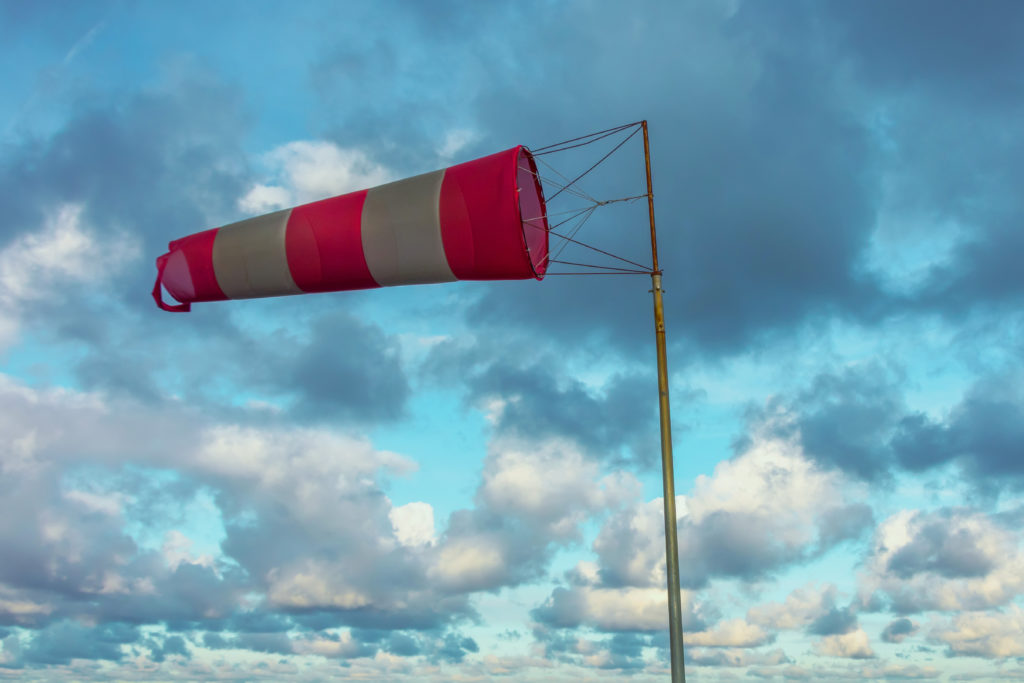 Image of a red and white windsock on a cloudy day