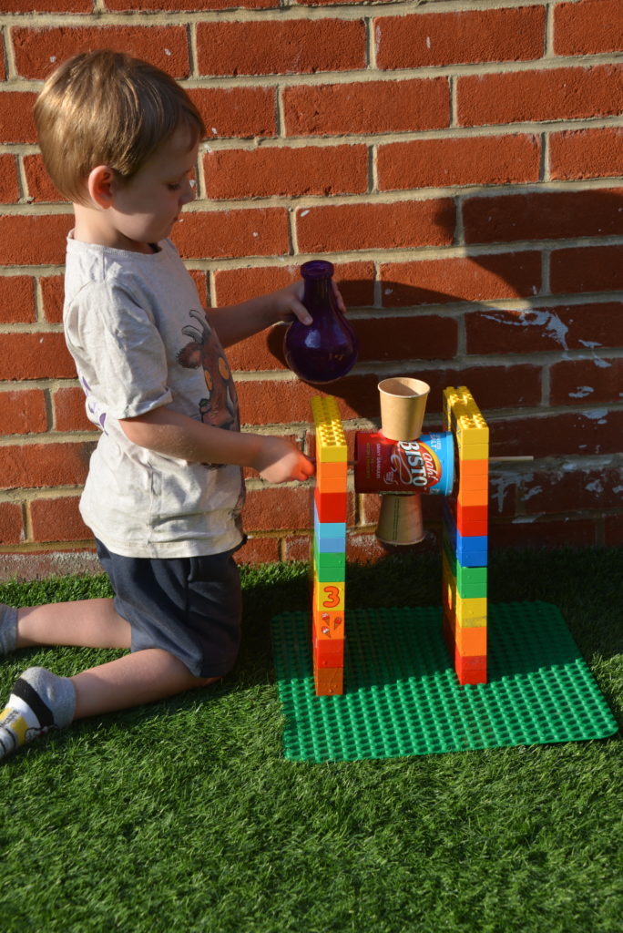 child testing a DIY water wheel