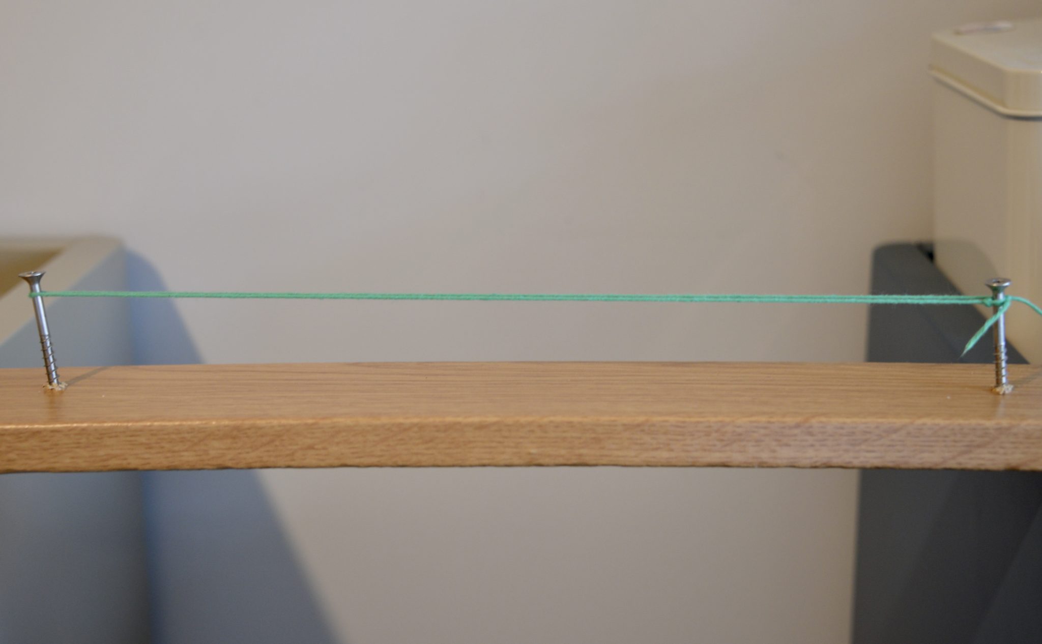 Transverse wave model 1 - image of a block of wood, with two screws and string between them