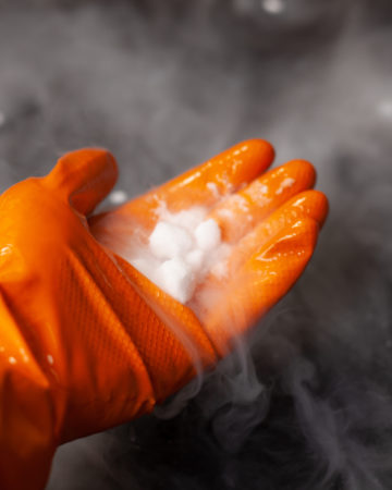 dry ice subliming into carbon dioxide gas in a gloved hand