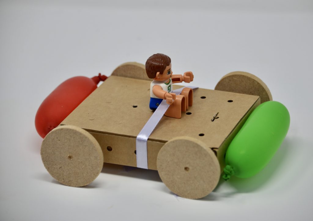 Cardboard car made with balloon bumper for a car themed STEM challenge