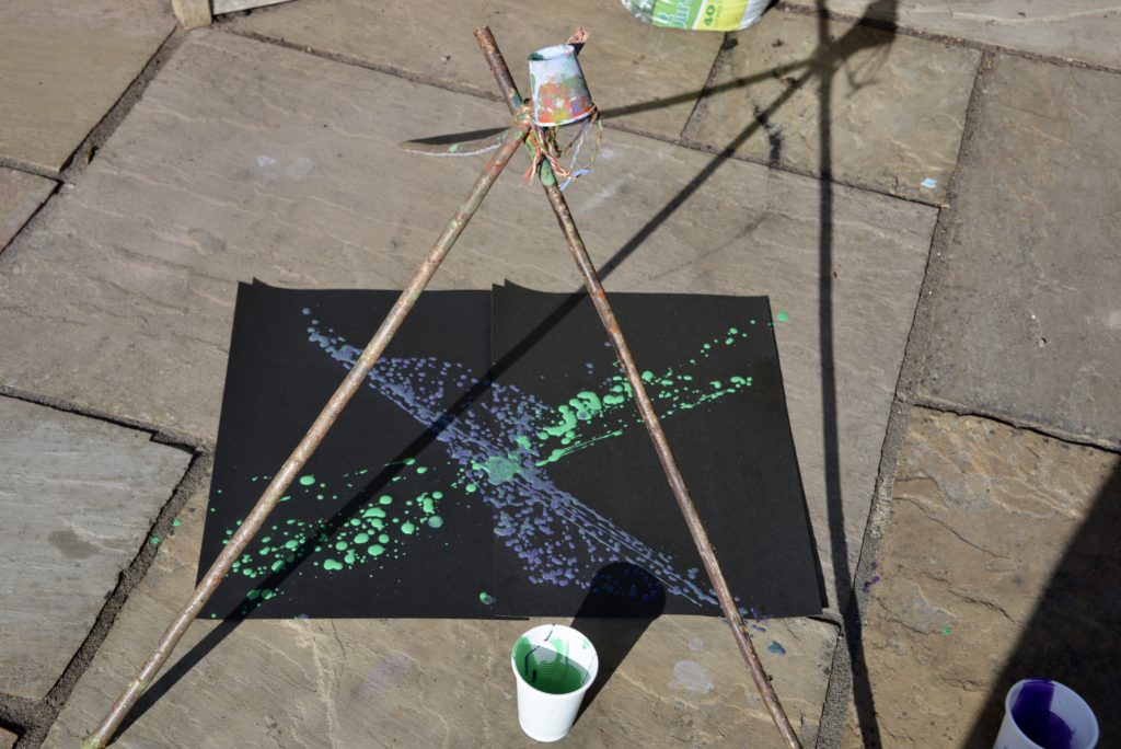 pendulum painting - image of a frame made from wooden skewers with a small paper cup suspended from the centre.