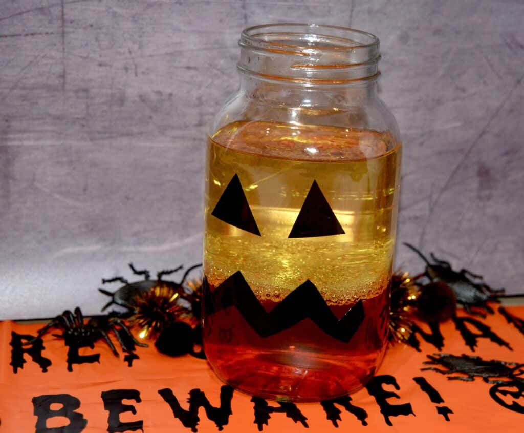 jar decorated like a pumpkin for a Halloween science activity making a lava lamp