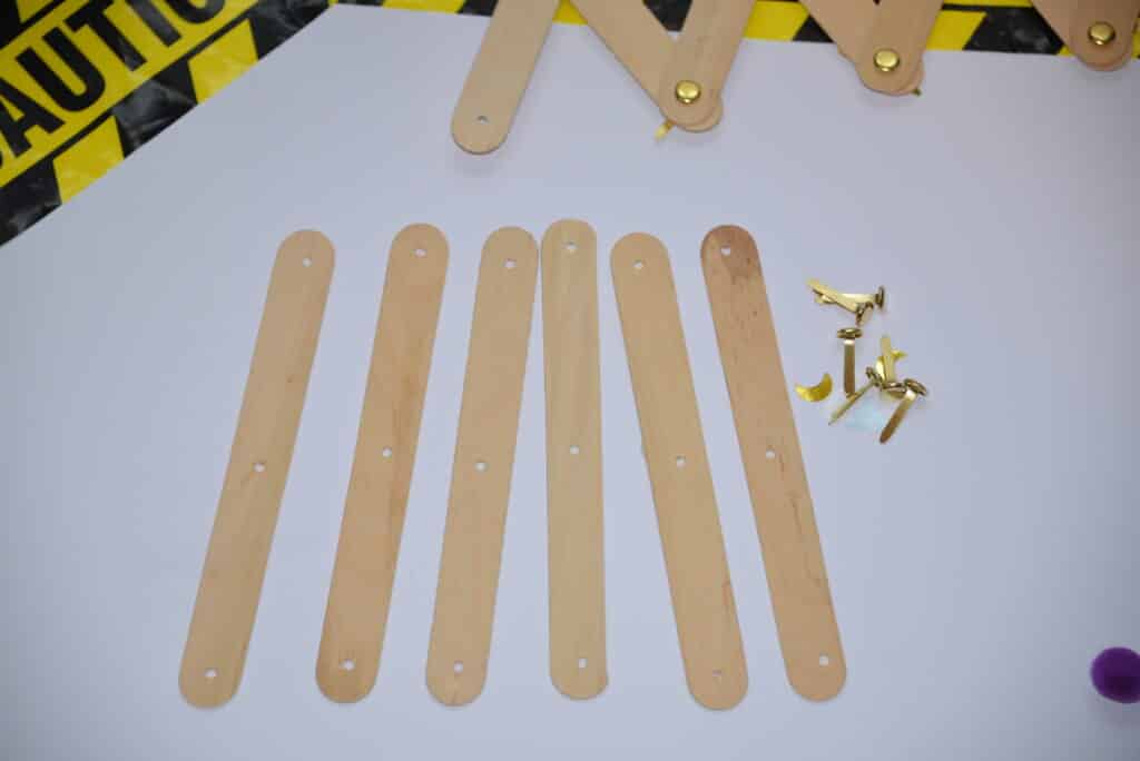 Craft sticks and split pins laid out on a white background