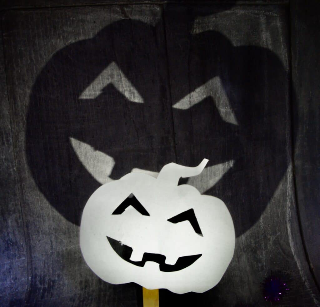 Pumpkin shadow puppet with a torch behind it to show the shadow