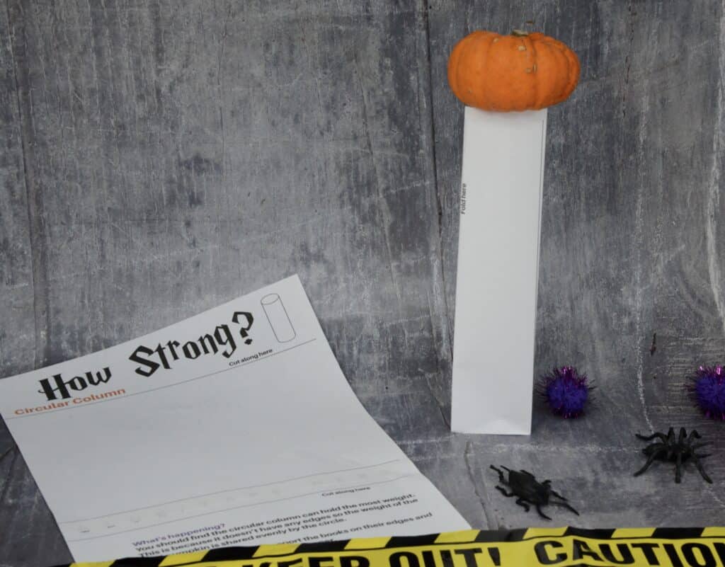 Image of a triangle paper column with a mini pumpkin on top for learning about strong shapes.