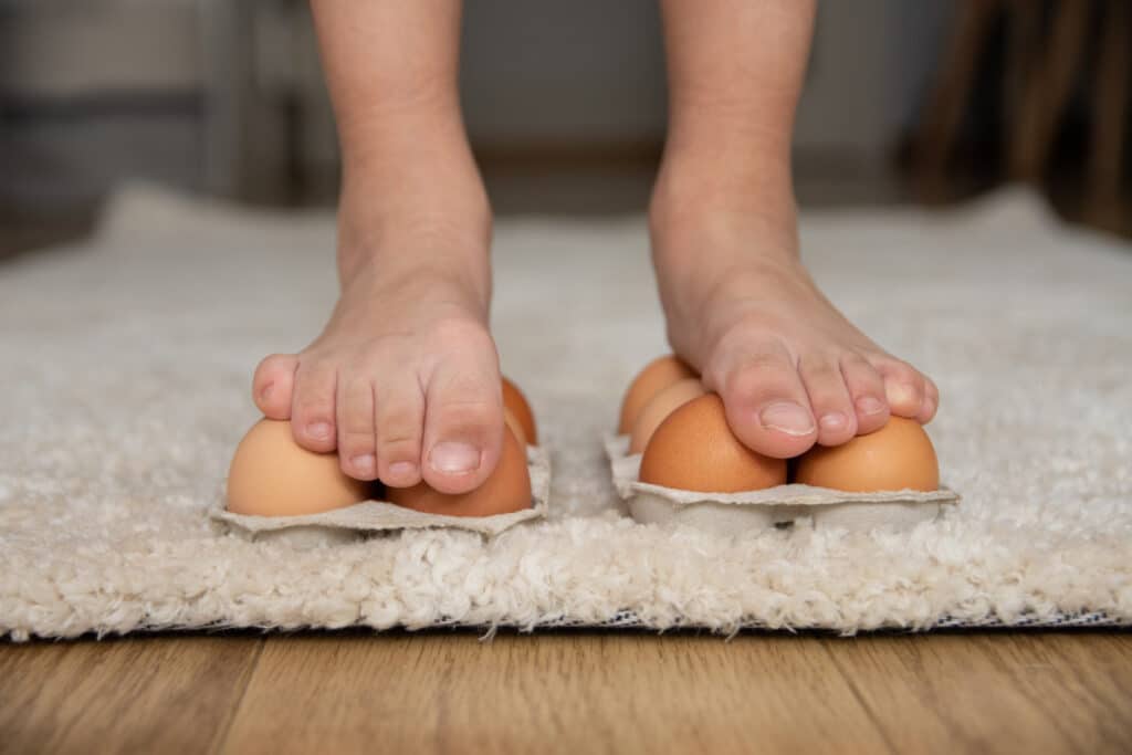 child standing on eggs with bare feet