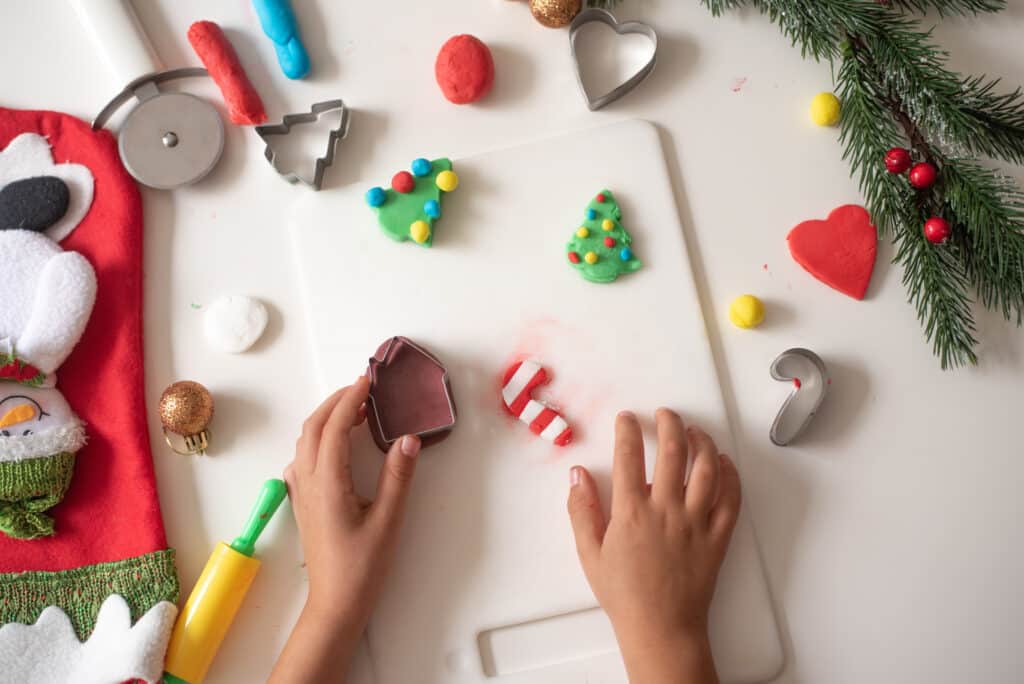 child's hands playing with Christmas themed play dough