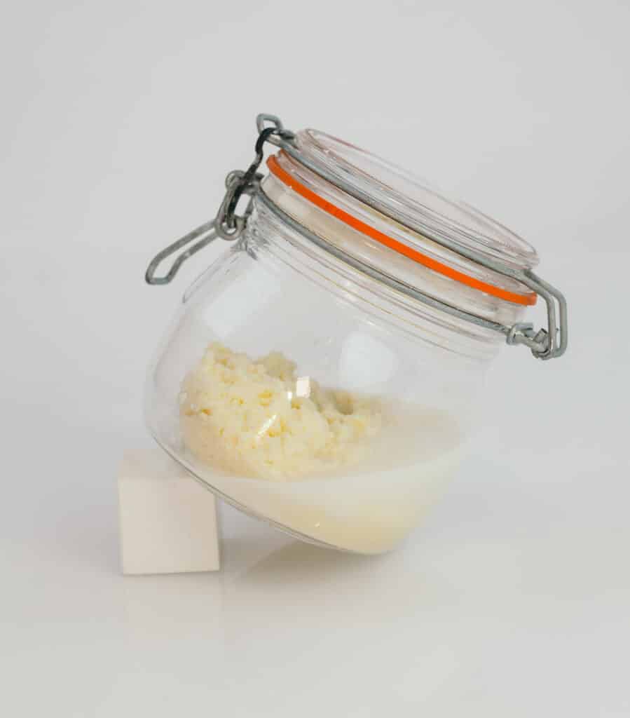 A jar containing butter and buttermilk made from cream