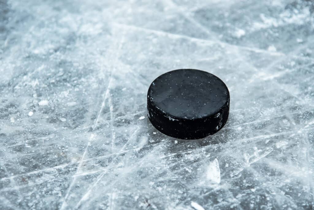 hockey puck lies on the snow macro