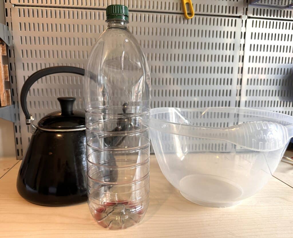 Materials needed for a collapsing bottle air pressure experiment - kettle of hot water, plastic bottle with lid and large bowl