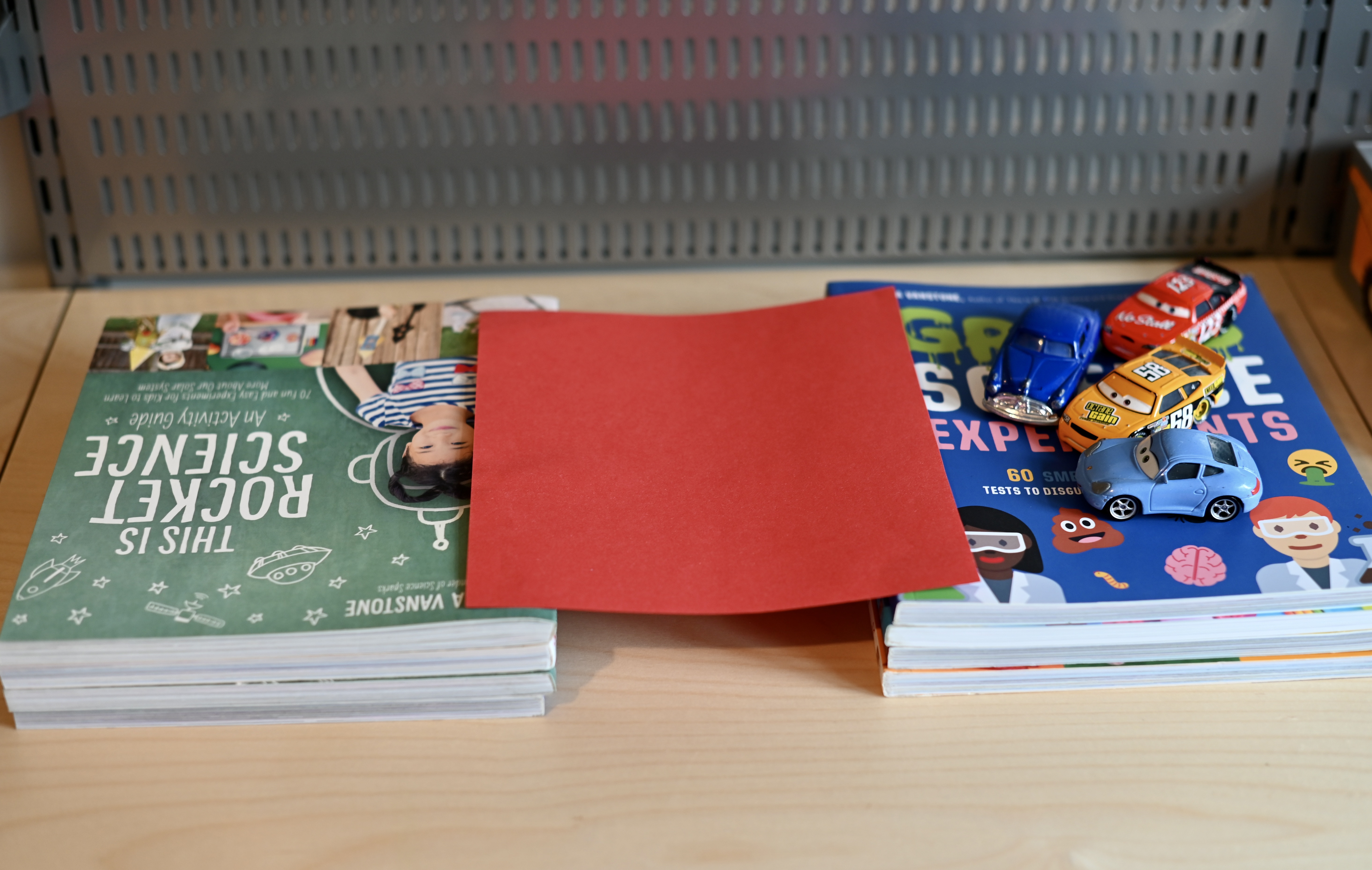 Two piles of books with a sheet of red paper between them to act as a bridge