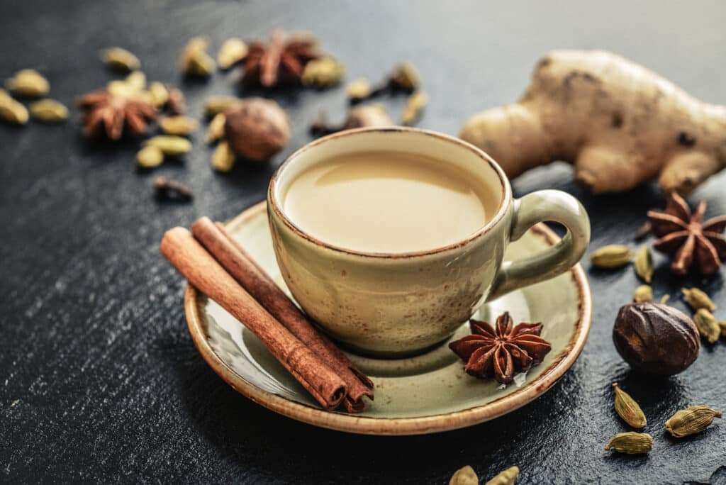 a cup of Indian chai tea surrounded by spices