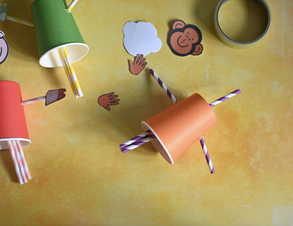 three straws pushed through a paper cup to make a puppet