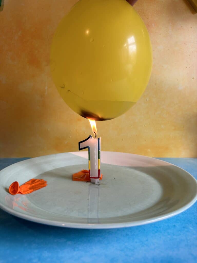 El globo que contiene el agua puesto en la llama de una vela.