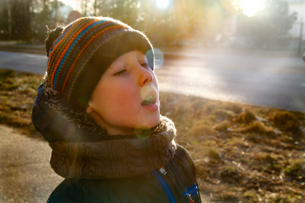 boy breathing on a cold day. Image shows water vapour being breathed out.