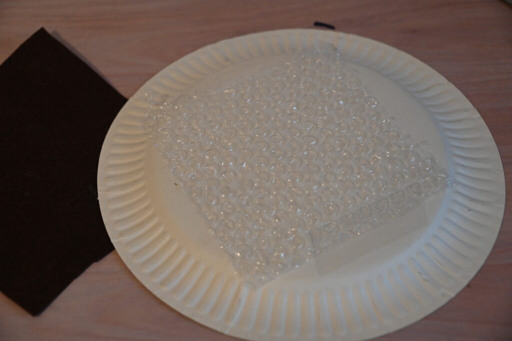 paper plate covered in bubble wrap for a curling STEM challenge